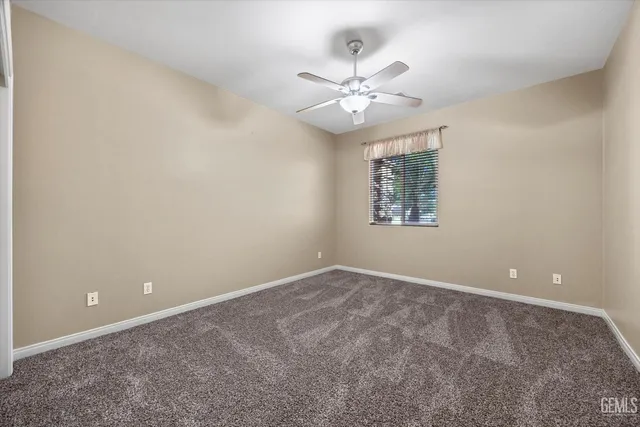 an empty room with closet and a chandelier fan