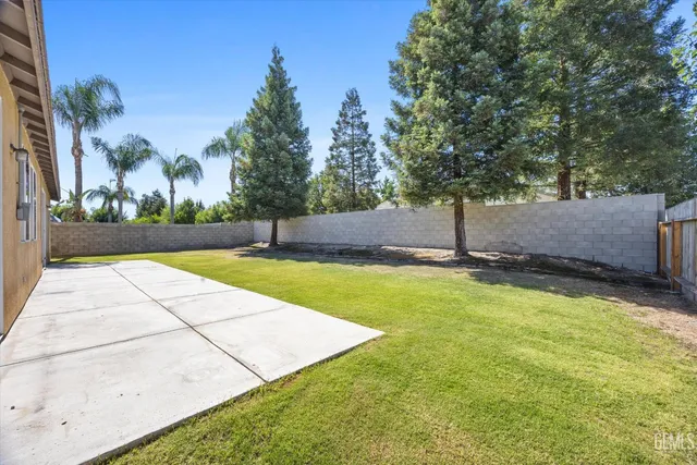a view of a house with backyard and trees