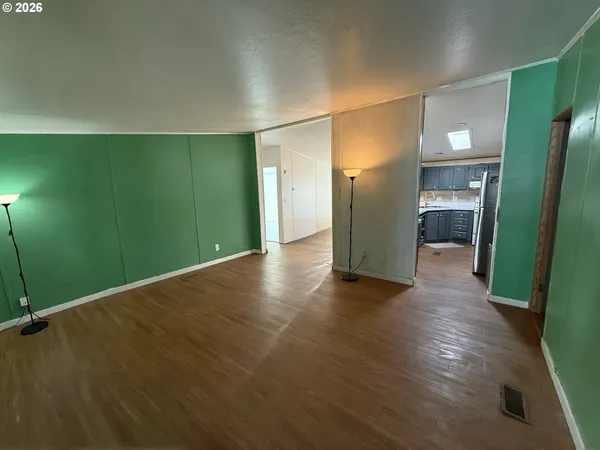 a view of a big room with wooden floor and a bathroom