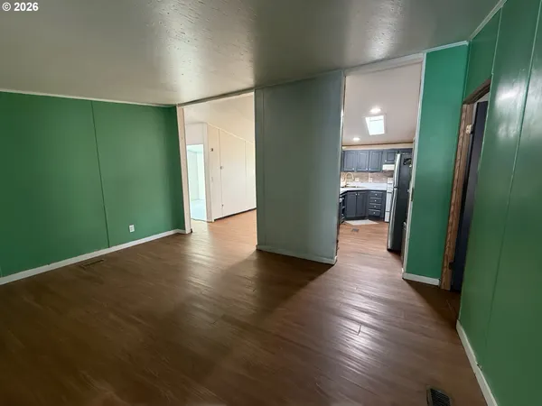 an empty room with wooden floor and mirror