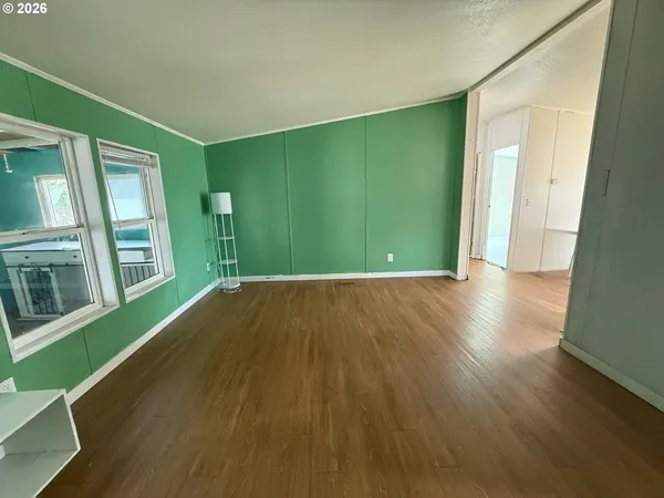a view of a room with wooden floor and entryway