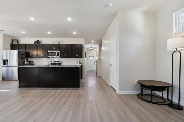 a living room kitchen with furniture and a flat screen tv