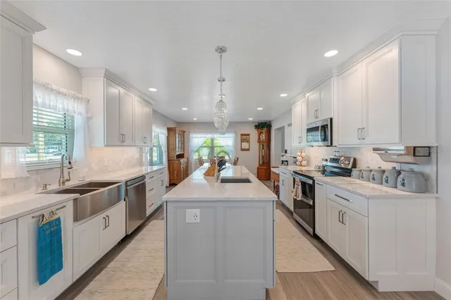 a large kitchen with kitchen island a sink a counter space and stainless steel appliances