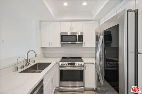 a kitchen with stainless steel appliances a stove a sink and a microwave