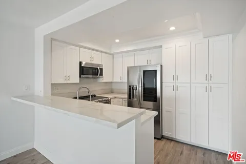 a kitchen with cabinets and stainless steel appliances