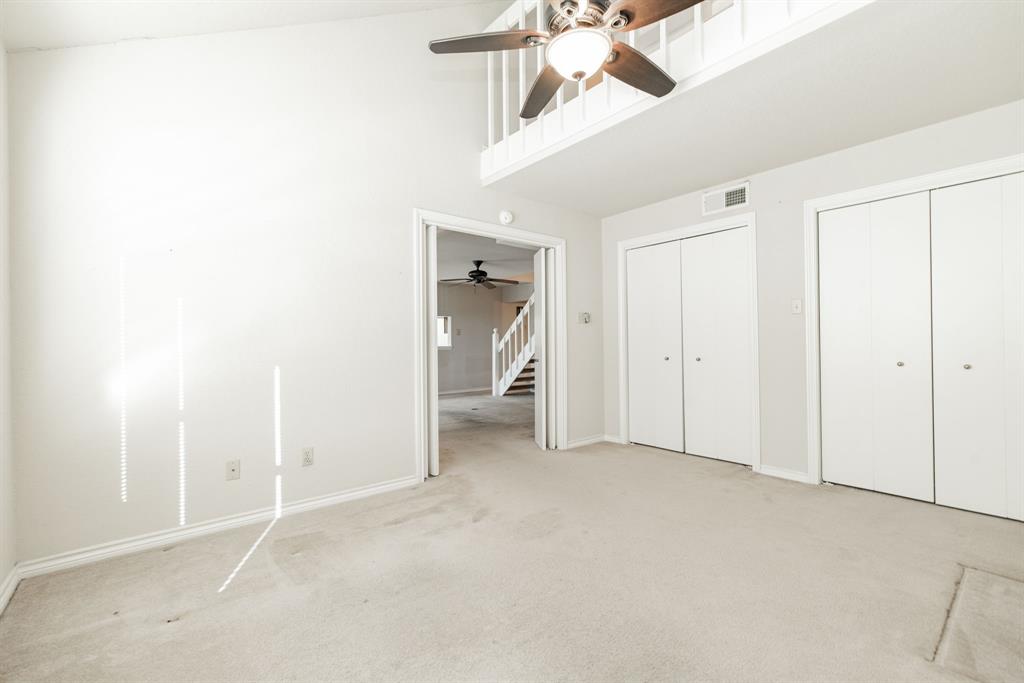 1106 Signal Ridge Place Rockwall, TX 75032 - Photo 14 of 32 Unfurnished bedroom with multiple closets, carpet, a towering ceiling, and a ceiling fan