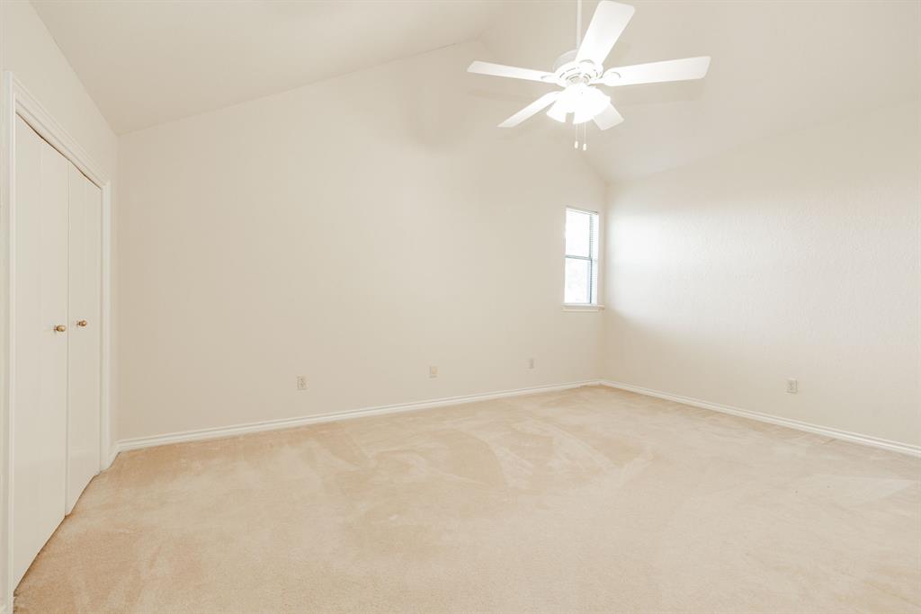 1106 Signal Ridge Place Rockwall, TX 75032 - Photo 27 of 32 an empty room with a chandelier fan and windows