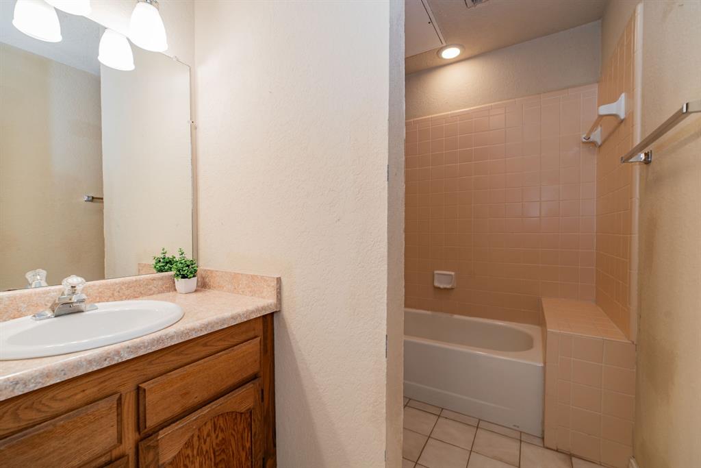 1106 Signal Ridge Place Rockwall, TX 75032 - Photo 31 of 32 Bathroom featuring vanity, a textured wall, light tile patterned floors, and washtub / shower combination
