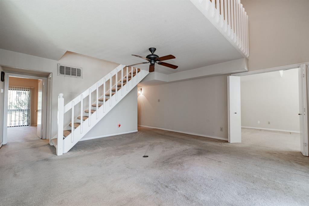 1106 Signal Ridge Place Rockwall, TX 75032 - Photo 5 of 32 Unfurnished living room with carpet flooring, ceiling fan, and stairs