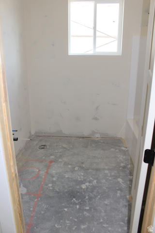 4933 East Remington Road Cedar City, UT 84721 - Photo 12 of 33 Unfinished interior space featuring a single-pane window, rough concrete flooring, and exposed plumbing connections