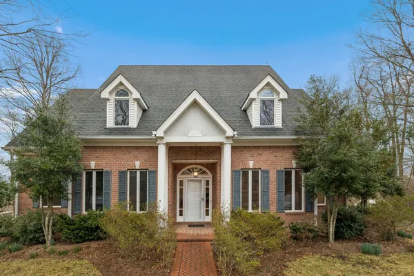 a view of a white house next to a yard