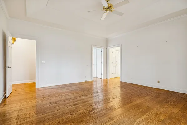 an empty room with a ceiling fan and window