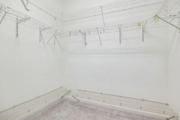 an empty room with closet and a chandelier fan