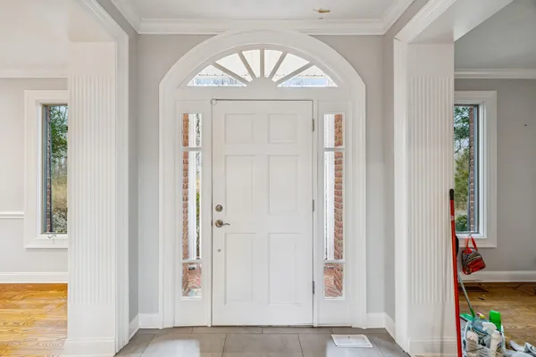 a view of an empty room with wooden floor and a fireplace