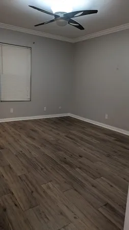 a view of an empty room with wooden floor