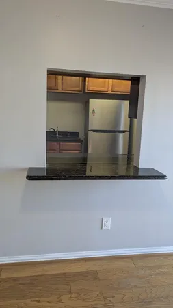 an empty room with wooden floor cabinet and windows