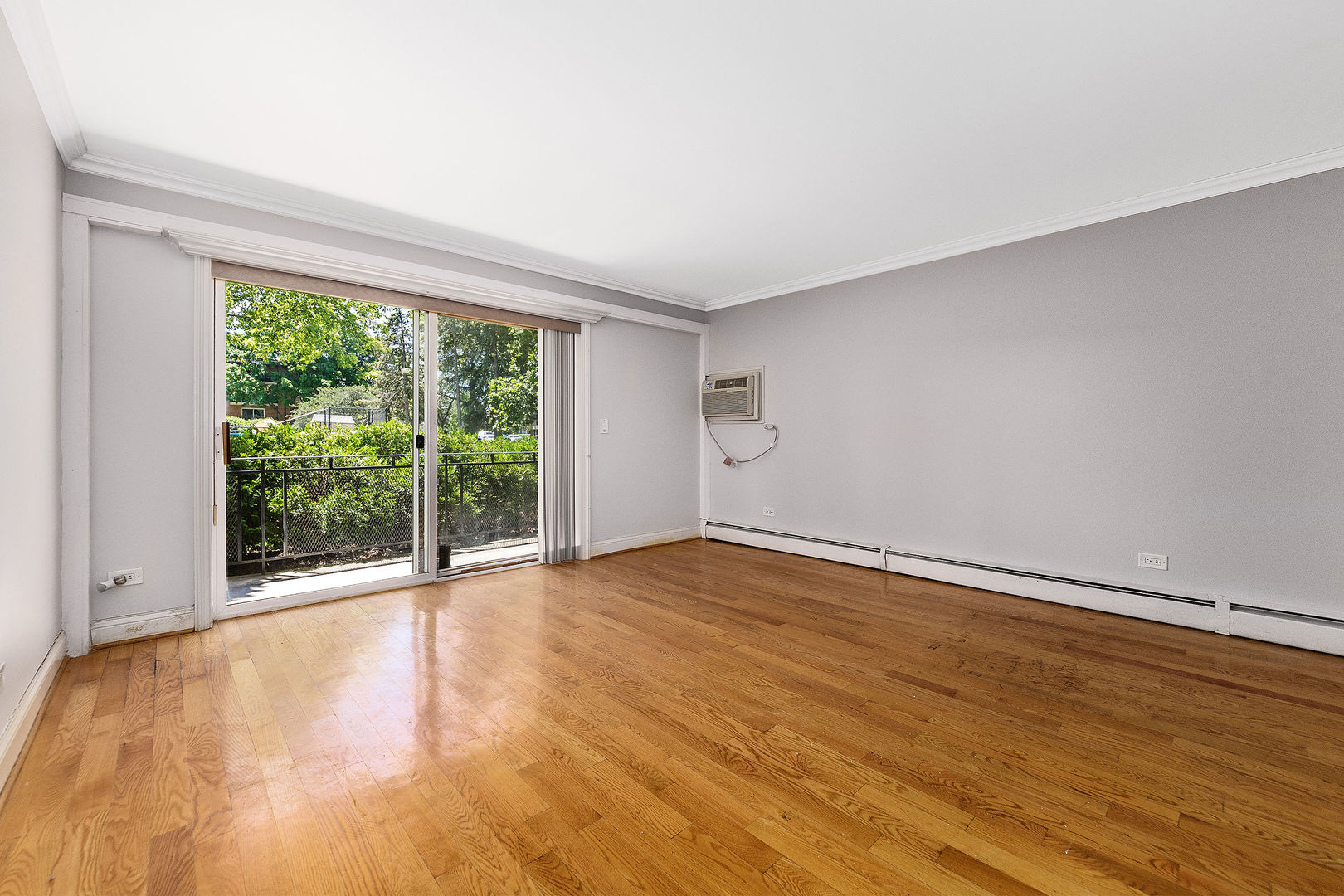 2210 South Goebbert Road, Unit 134 Arlington Heights, IL 60005 - Photo 4 of 10 a view of an empty room with wooden floor and a window