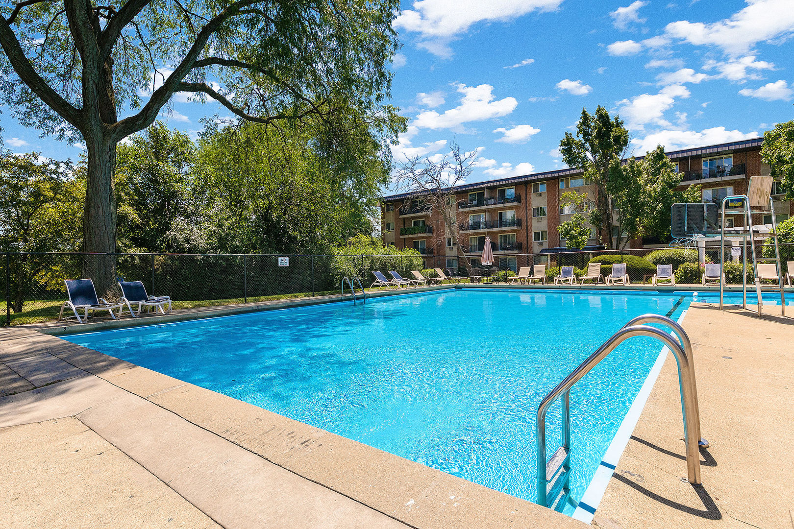 2210 South Goebbert Road, Unit 134 Arlington Heights, IL 60005 - Photo 10 of 10 a view of a swimming pool with a patio and a garden