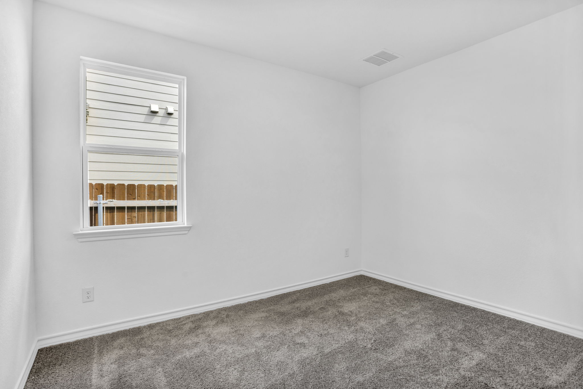 131 Adeline Road Hutto, TX 78634 - Photo 12 of 30 A well-lit bedroom with fresh, clean carpeting and ample natural light from the window.
