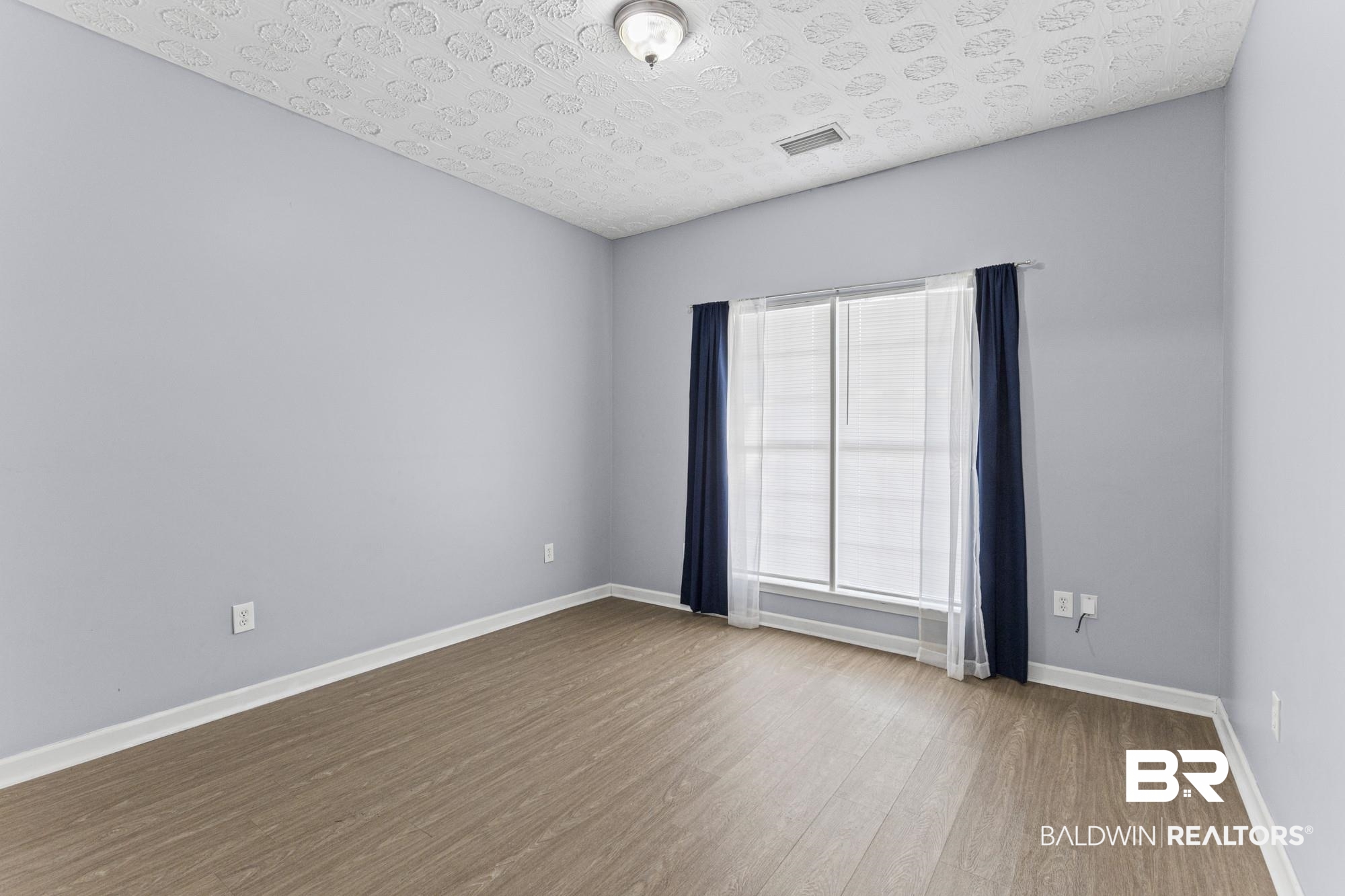 1153 Sloane Cove Foley, AL 36535 - Photo 20 of 25 Spare room featuring wood finished floors and a textured ceiling