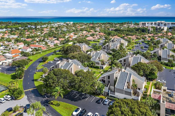 an aerial view of residential houses with outdoor space and trees all around