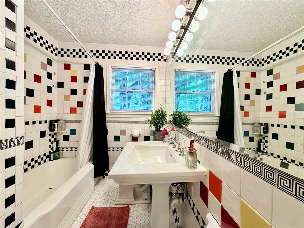 919 Denton Street Denton, TX 76201 - Photo 12 of 19 a bathroom with a sink mirror and a bathtub