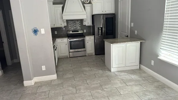 a kitchen with a refrigerator and a stove
