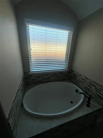 a bath tub sitting in a bathroom next to a window