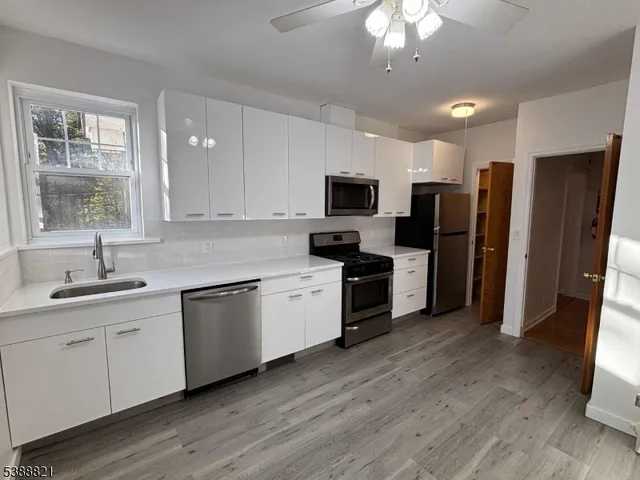 a kitchen with a sink stainless steel appliances and window