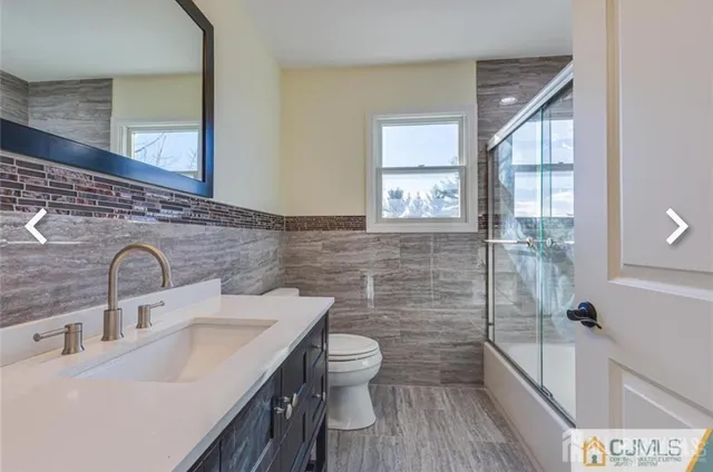 a bathroom with a sink and mirror with toilet