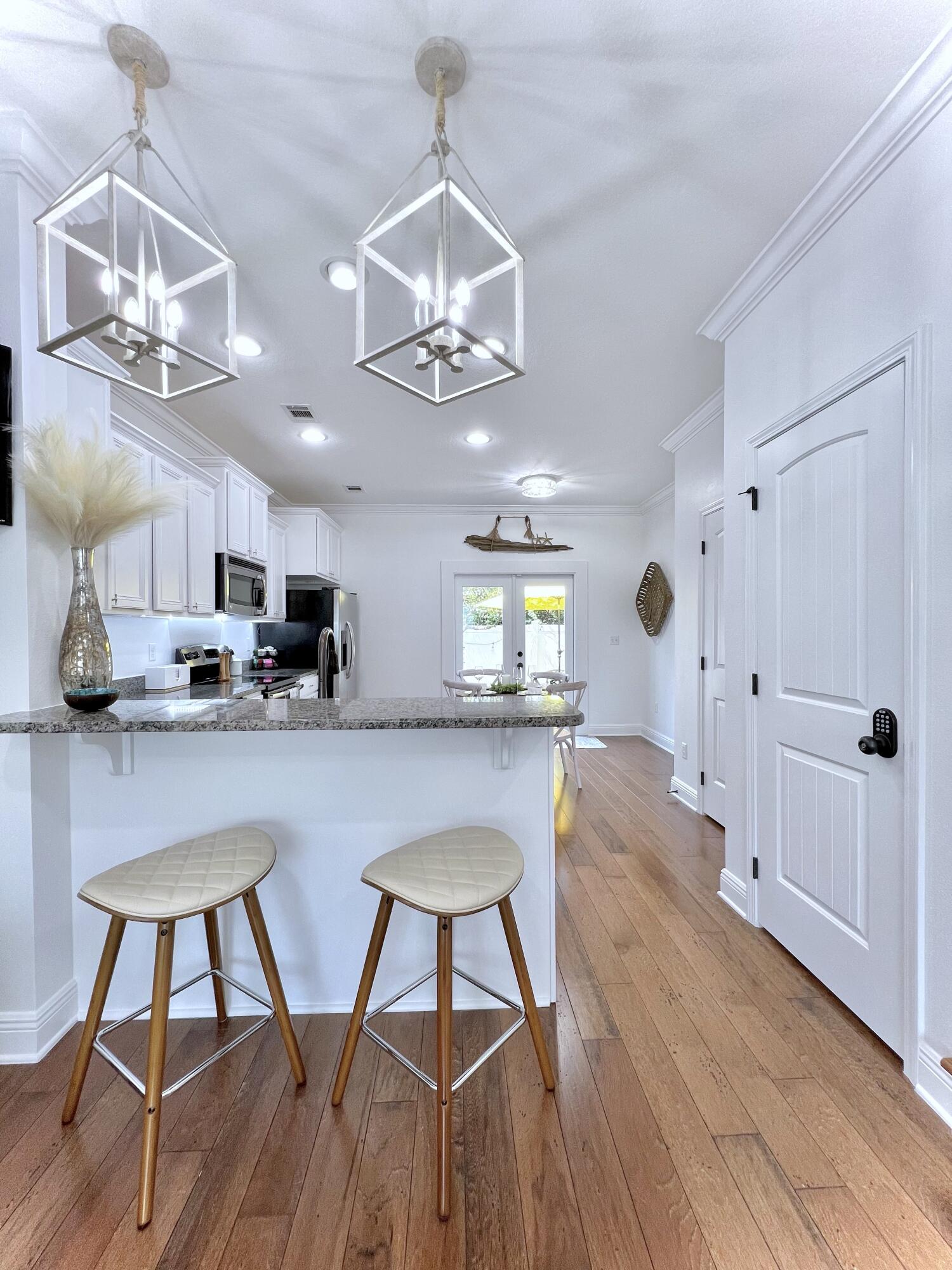 27 Grayling Way Inlet Beach, FL 32461 - Photo 14 of 33 a kitchen with stainless steel appliances a table chairs refrigerator and wooden floor