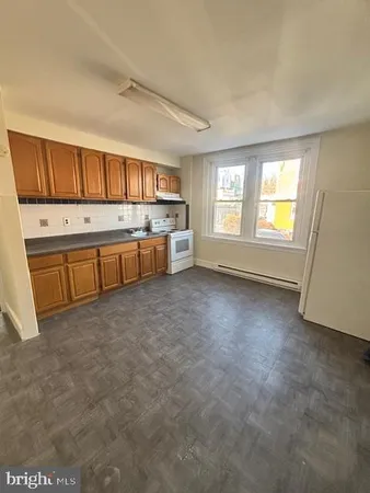 a large kitchen with a stove a sink dishwasher and a refrigerator