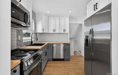 a kitchen with stainless steel appliances granite countertop a stove a refrigerator and a sink