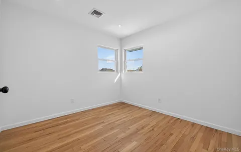 a view of a room with wooden floor and white walls