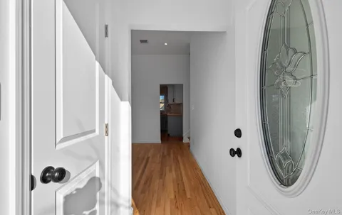 a view of a hallway with wooden floor and entryway