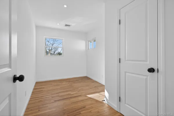 a bedroom with a baby bed a couch and a window