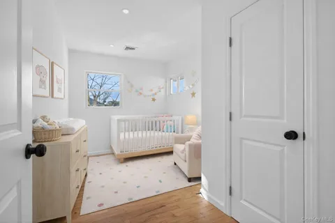 a bedroom with a baby bed a couch and a window