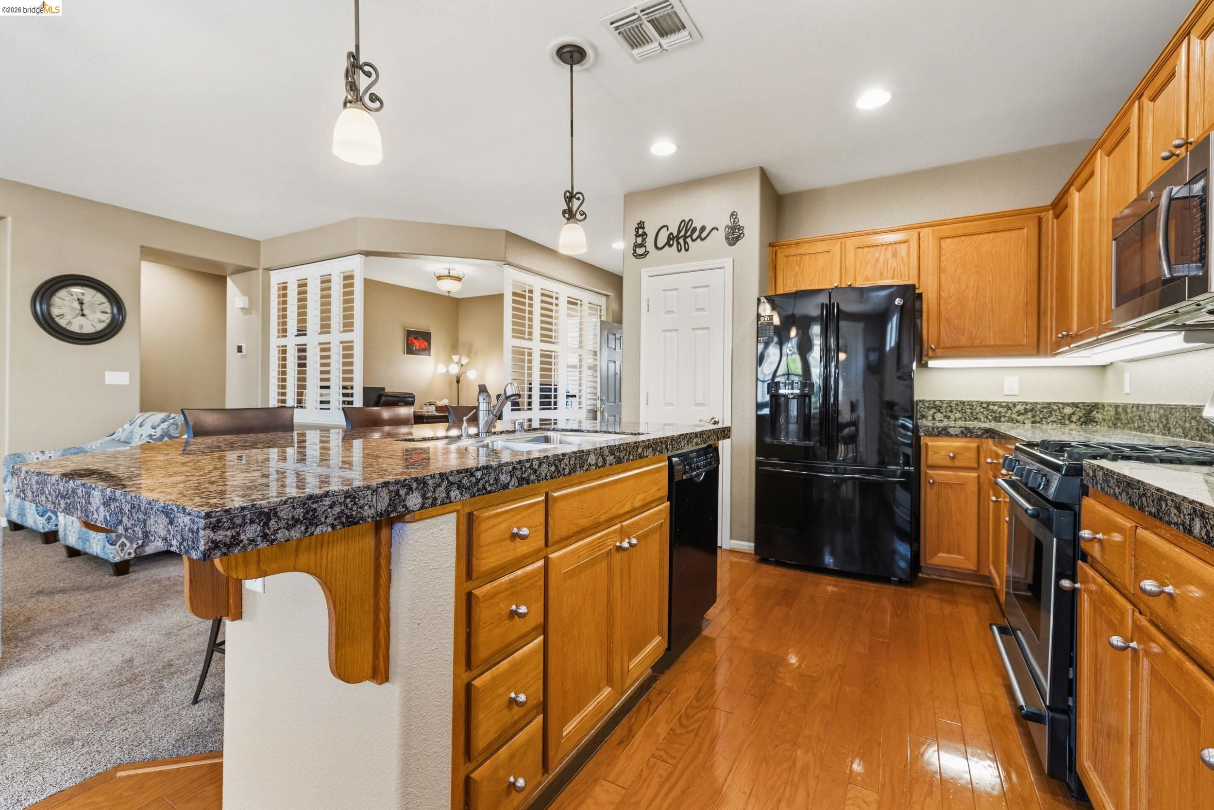 1063 Waterwood Drive Rio Vista, CA 94571 - Photo 13 of 38 a kitchen with granite countertop a refrigerator a stove and a sink