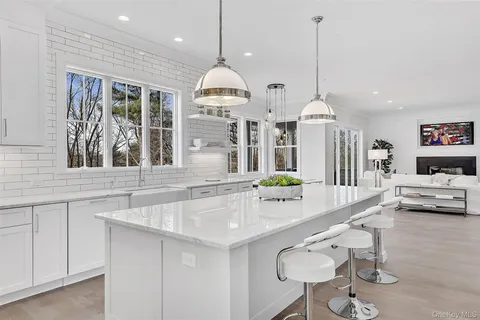 a kitchen with stainless steel appliances granite countertop a sink a stove and a wooden floors