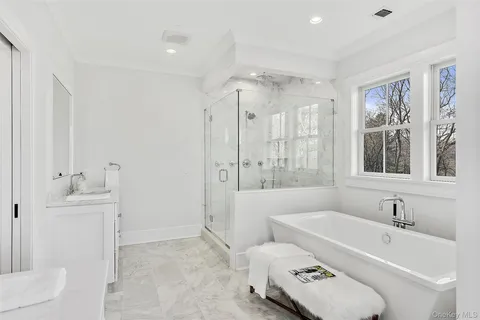 a bathroom with a tub sink toilet and mirror