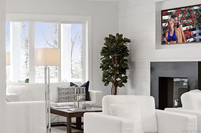 a living room with furniture a large window and a fireplace