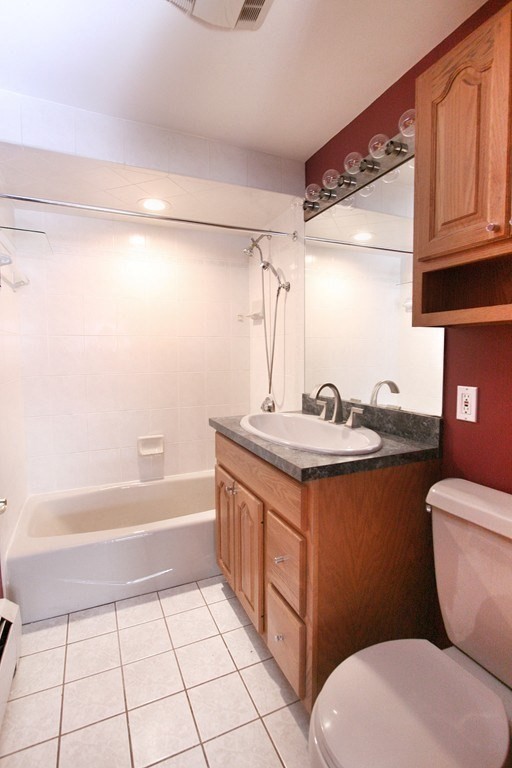 311 Ridge Street Arlington, MA 02474 - Photo 14 of 15 a bathroom with a granite countertop sink a toilet a mirror and bathtub