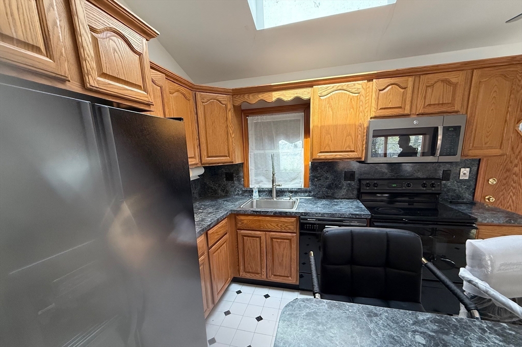 311 Ridge Street Arlington, MA 02474 - Photo 2 of 15 a kitchen with stainless steel appliances granite countertop a sink stove and cabinets