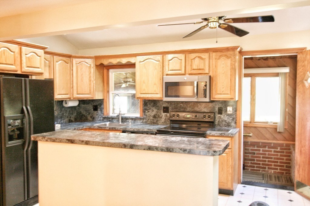 311 Ridge Street Arlington, MA 02474 - Photo 3 of 15 a kitchen with stainless steel appliances granite countertop a refrigerator a stove and a sink with large window