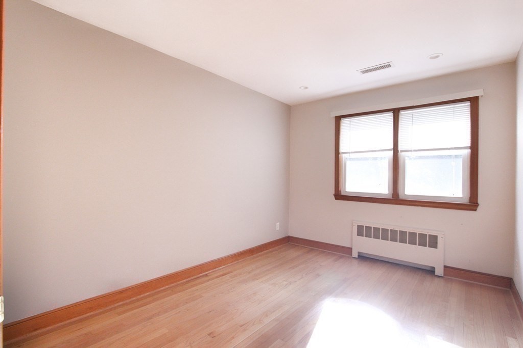 311 Ridge Street Arlington, MA 02474 - Photo 6 of 15 an empty room with wooden floor and windows