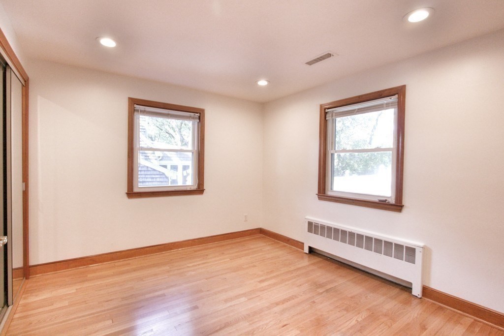 311 Ridge Street Arlington, MA 02474 - Photo 7 of 15 an empty room with wooden floor and windows