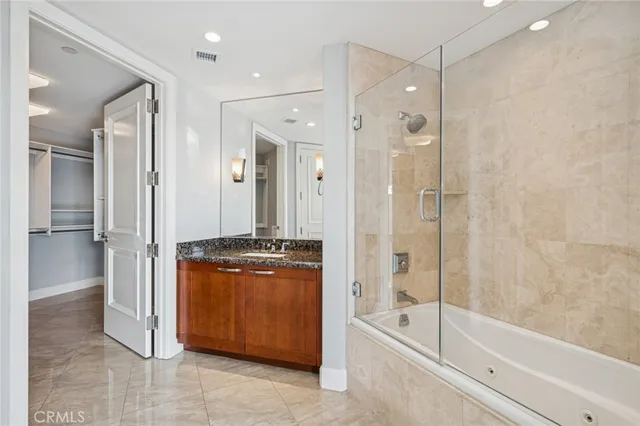 a bathroom with a granite countertop sink a mirror and a bathtub
