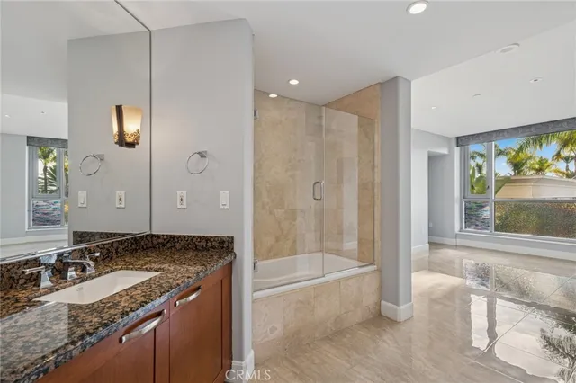 a bathroom with a granite countertop tub sink and mirror