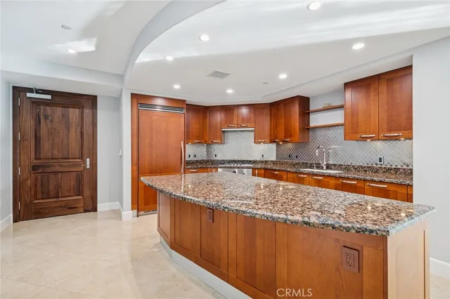 a kitchen with stainless steel appliances granite countertop a sink stove and refrigerator