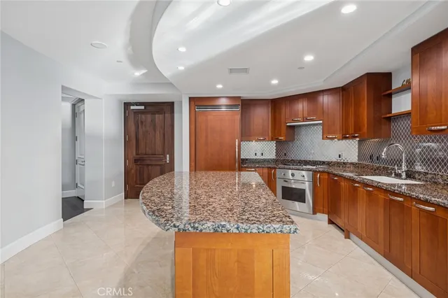 a kitchen with stainless steel appliances granite countertop a sink and a refrigerator